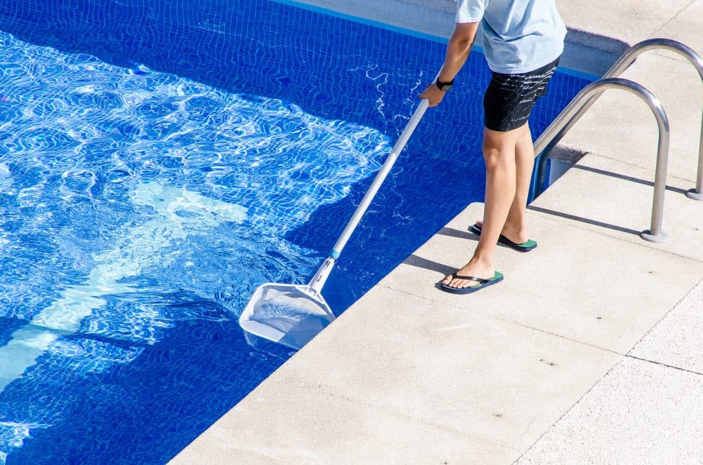 Pool service technician maintaining a swimming pool